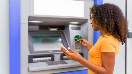 Portrait of young afro woman using credit card